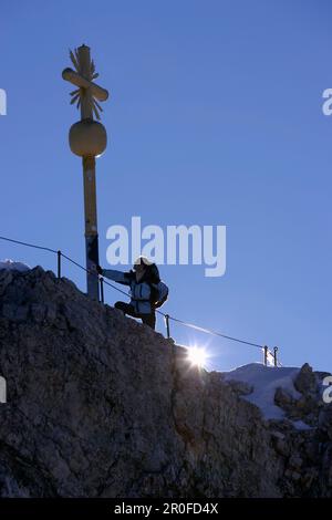 Mann auf dem Gipfel der Zugspitze am Morgen, Bayern, Deutschland Stockfoto