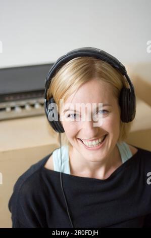 Junge Frau, die Musik über Kopfhörer hören Stockfoto