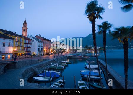 Hafen und Hafenpromenade mit Kirchturm Santi Pietro Paolo im Hintergrund am Abend, Ascona, Lago Maggiore, Tessin, Schweiz Stockfoto