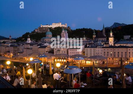 Blick über die beleuchtete Dachterrasse des Restaurants Hotel Stein zur Altstadt mit Salzburger Dom, St. Peters Erzabtei, Franziskanerkirche, Rathaustrag Stockfoto