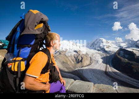 Männlicher Alpinist in der Nähe des Kulmhotels, dem höchsten Hotel der Schweizer Alpen 3100 m, am Gornergrat mit Blick auf die Dufourspitze 4634 m, den höchsten Berg Stockfoto