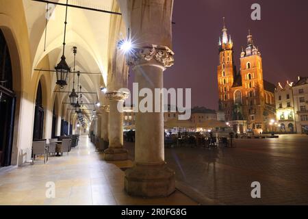 Blick auf die St. Marys Basilika von den Bögen der Tuchhalle bei Nacht. Krakau, Polen, Europa. Stockfoto