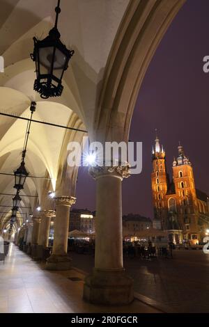 Blick auf die St. Marys Basilika von den Bögen der Tuchhalle bei Nacht. Krakau, Polen, Europa. Stockfoto