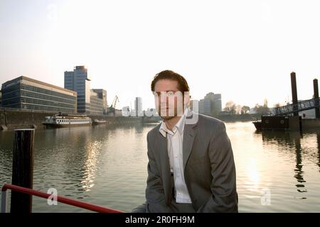 Junger Geschäftsmann vor dem Media Harbour, Landeshauptstadt NRW, Nordrhein-Westfalen, Deutschland Stockfoto