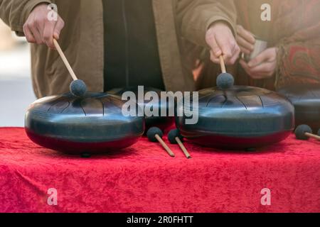 Stahlzunge, Trommel. Klangschale, Stahltrommel und Drumsticks. Instrument für Klangwellentherapie und Meditation, Heilung. Stockfoto