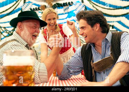 Zwei Männer Armdrücken in einem Bierzelt Stockfoto