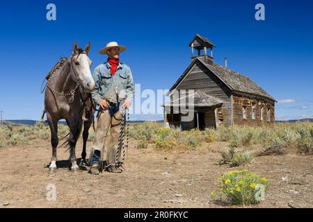 Cowboy mit Pferd im alten Schulhaus in wildwest, Oregon, USA Stockfoto