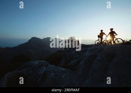 Zwei Mountainbiker bei Sonnenuntergang, Torret de Pareis, Mallorca, Balearen, Spanien Stockfoto