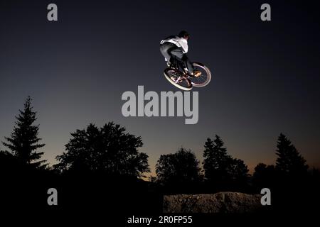 Mountainbiker-Sprung, Oberammergau, Bayern, Deutschland Stockfoto