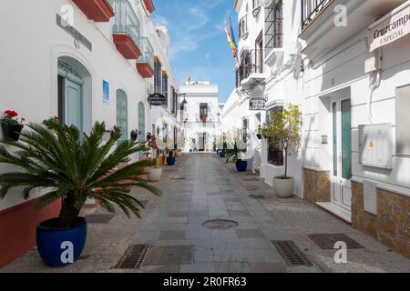 Chipiona, Cadiz, Spanien - 19. April 2023: Schöne Straße mit Blumentöpfen in Chipiona, Andalusien, Südspanien. Stockfoto