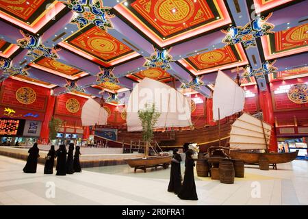 Dubai Ibn Battuta Mall, chinesische Dekoration, Dhows, arabische Segelboote, arabische Frauen in schwarzem Abaya Stockfoto