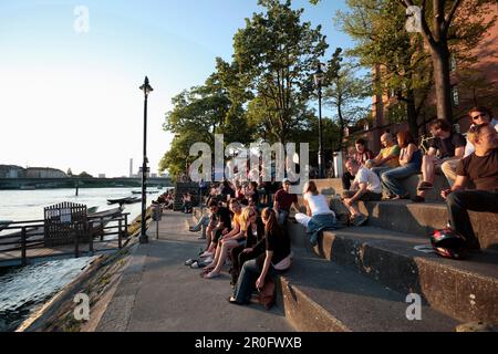 Menschen, die sich auf den Stufen der Promenade, des Rheins, der Riviera Klein-Basel, Basel, Schweiz entspannen Stockfoto