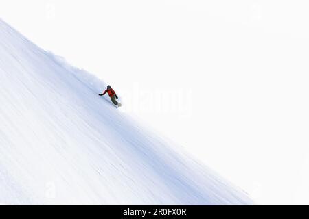 Snowboarder-Schnitzerei geht bergab, siehe, Skiregion Paznaun, Tirol, Österreich Stockfoto