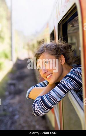 Junge Frau aus einem Fenster von einem rasenden Zug Stockfoto