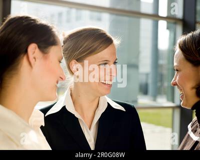 Drei Geschäftsfrauen, die reden und lachen, München, Bayern, Deutschland Stockfoto