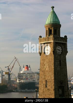 Uhrenturm und Kreuzfahrtschiff Queen Mary 2 auf der Werft, Hansestadt Hamburg, Deutschland Stockfoto