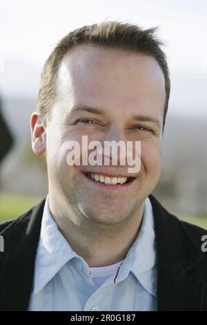 Mitte der erwachsenen Mann in die Kamera lächeln Stockfoto