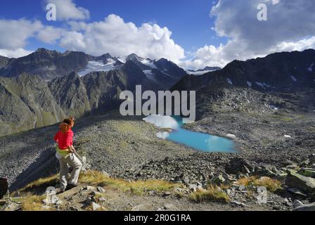 Eine Frau, die auf den Rinnensee, die Stubai-Alpen, Stubai, Tirol, Österreich schaut Stockfoto