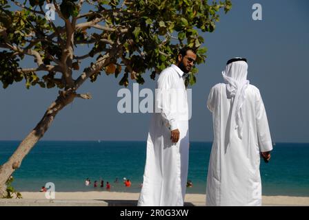 Zwei einheimische Männer vor dem Strand, Al Fujairah, Vereinigte Arabische Emirate Stockfoto