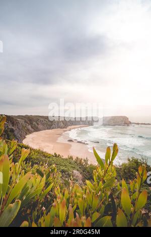 Der berühmte Strand Praia dos Machados in Odemira, westlich von Portugal. Die Felsen rund um den mondförmigen Sandstrand mit großen Wellen aus dem Atlantik Stockfoto