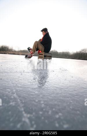 Älterer Mann, der Schlittschuh läuft, Ammersee, Oberbayern, Deutschland Stockfoto