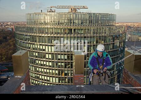 Industriekletterer arbeiten an Kollhoff-Tower mit DB-Turm im Hintergrund, Berlin Stockfoto