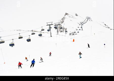 Skifahrer am Hang, Sessellift in Hintergrund, Hintertux, Tirol, Österreich Stockfoto