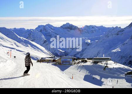 Weiblichen Snowboarder auf der Piste, Ski-Hütte im Hintergrund, Davos, Graubünden, Schweiz Stockfoto