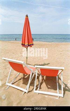 Zwei rote Liegestühle und ein Sonnenschirm am Strand, Meer, Castellabate, Cilento, Italien Stockfoto