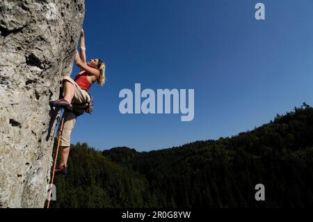 Frau Klettern auf einer Felswand in der Sonne, Fränkische Schweiz, Bayern, Deutschland, Europa Stockfoto