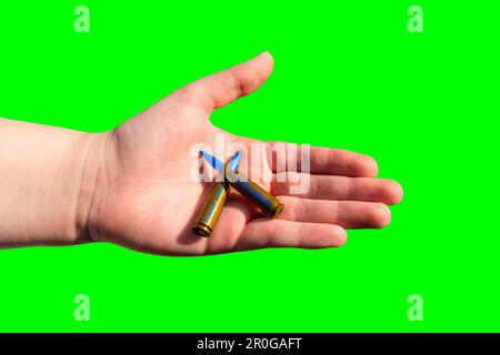Zwei gelb-blaue Gewehrpatronen mit dem AUFKLEBERSTÄNDER MIT UKRAINE in der Hand auf grünem Hintergrund (Chroma Key) Stockfoto