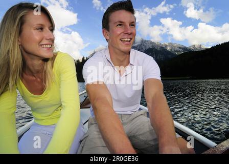 Junges Paar im Ruderboot, See Lautersee, Mittenwald, Werdenfelser Land, Oberbayern, Deutschland Stockfoto