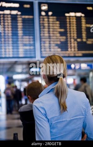 Frau, die Fluginformationstafel liest, Flughafen München, Bayern, Deutschland Stockfoto