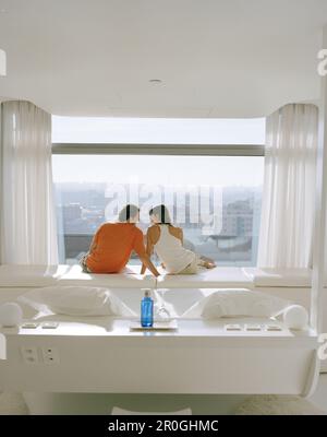 Ein Paar saß am Fenster und genoss die Aussicht, Zimmer im 8. Stock, entworfen von Kathryn Findlay, Hotel Silken Puerta America, Madrid, Spanien Stockfoto