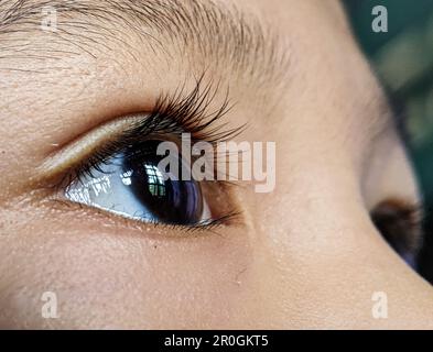 Ein Nahporträt eines bezaubernden jungen Mädchens mit großen Augen Stockfoto