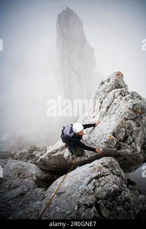 Weibliche Bergsteiger am Kopftoerlgrat, Kapuzenturm im Hintergrund, Ellmauer Halt, Kaisergebirge, Tirol, Österreich Stockfoto