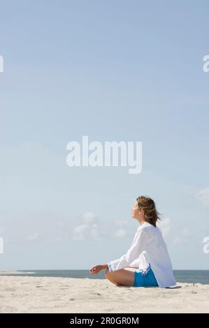 Frau, die Yoga am Sandstrand, List, Sylt, Schleswig-Holstein, Deutschland, praktiziert Stockfoto