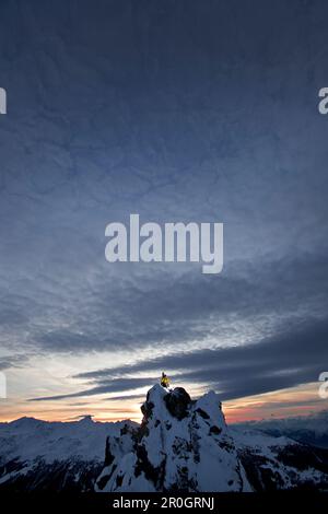 Snowboarder stehen auf einem Berg in der Dämmerung, Chandolin, Anniviers, Wallis, Schweiz Stockfoto