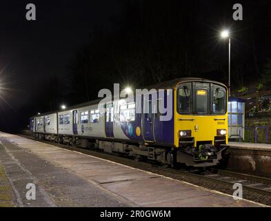 Zug der Northern Rail Klasse 150 150141 ruft in einer dunklen Nacht am Bahnhof Westhoughton an Stockfoto