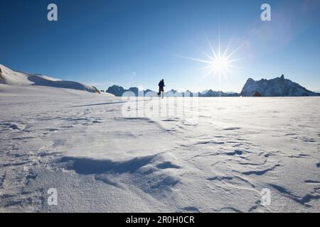 Mann, der über den Gletscher zum Sonnenaufgang fährt, mit Blick auf Les Grandes Jorasses und Dent du Geant, Chamonix Mont Blanc, Frankreich, Europa Stockfoto