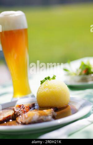 Schweinebraten und Weizenbier, Weißbier in einem Biergarten bei Kochel, Oberbayern, Bayern, Deutschland Stockfoto