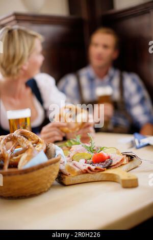 Ein Paar in traditionellen Kostümen, das einen Snack serviert Stockfoto