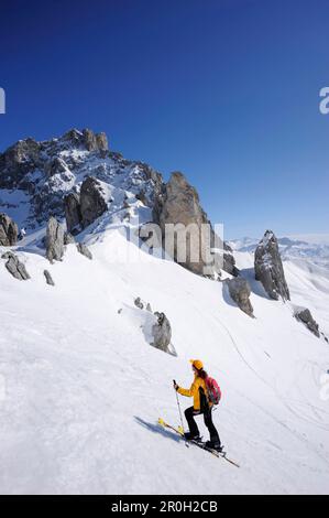 Frau im Hinterland Ski fahren, aufsteigen Richtung Notch Schweizer Tor, Blick Richtung Drusenfluh, St. Antoenien, Praettigau, Grisons, Schweiz Stockfoto