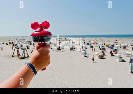 Eine Person zeigt den Luftgeschwindigkeitsmesser am Strand von St. Peter Ording, Nordfriesien, Schleswig-Holstein, Deutschland Stockfoto