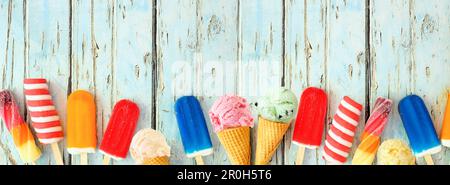 Auswahl an farbenfrohen Sommereissorten und Eisspezialitäten. Ansicht von oben Unterer Rand auf rustikalem blauem Holzbannerhintergrund. Speicherplatz kopieren. Stockfoto