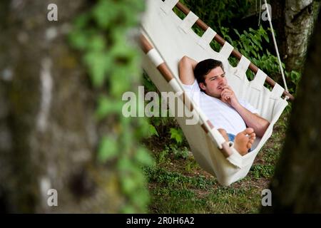 Mann liegen in der Hängematte, Kaltern, Bozen, Trentino-Alto Adige/Suedtirol, Italien Stockfoto