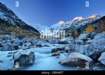 Der Fluss fließt im Morteratsch-Tal im Morgenlicht mit Bernina Range im Hintergrund, Bernina Range, Engadin, Grisons, Schweiz Stockfoto