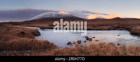 Sonnenaufgang über dem Rannoch Moor mit Blick auf den schneebedeckten Gipfel von Beinn Toaig im Glen Coe Valley, Schottland, Großbritannien Stockfoto