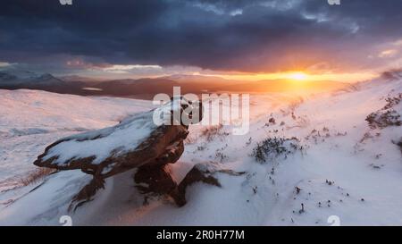 Fantastischer Sonnenuntergang über den schneebedeckten North West Highlands mit windgeschliffenem Torridon Sandstein im Vordergrund, Ullapool, Schottland, Großbritannien Stockfoto