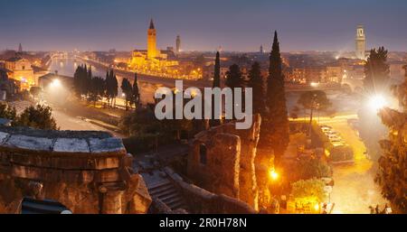 Blick auf Verona und den Fluss Etsch vom Teatro Romano bei Nacht mit den Kirchentürmen von Sant' Anastasia und der Kathedrale von Verona, Veneto, Italien Stockfoto